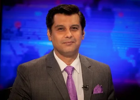 Arshad Sharif is smiling in grey suit